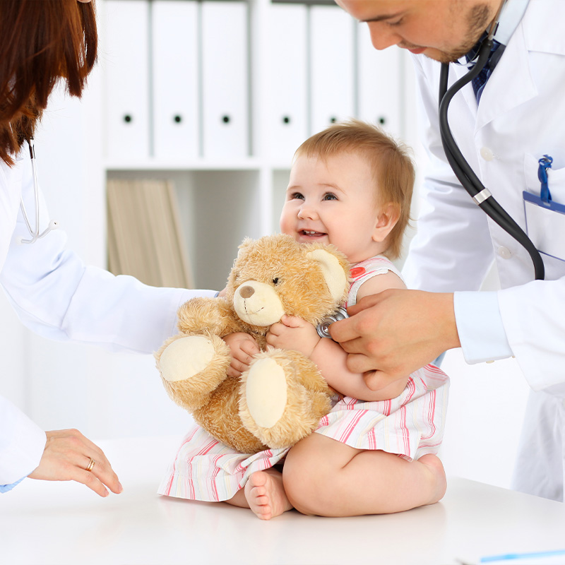 família com crianças em consulta pediátrica preventiva, pediatra explicando cuidados infantis, ambiente acolhedor